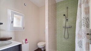 A bathroom with a toilet, a sink, and a shower area.