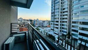 Ein Balkon mit Blick auf ein modernes Hochhaus und eine MapleBear Canadian School im Hintergrund.