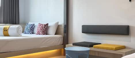 Una habitación de hotel moderna con cama, mesita de noche y lámpara de pared.