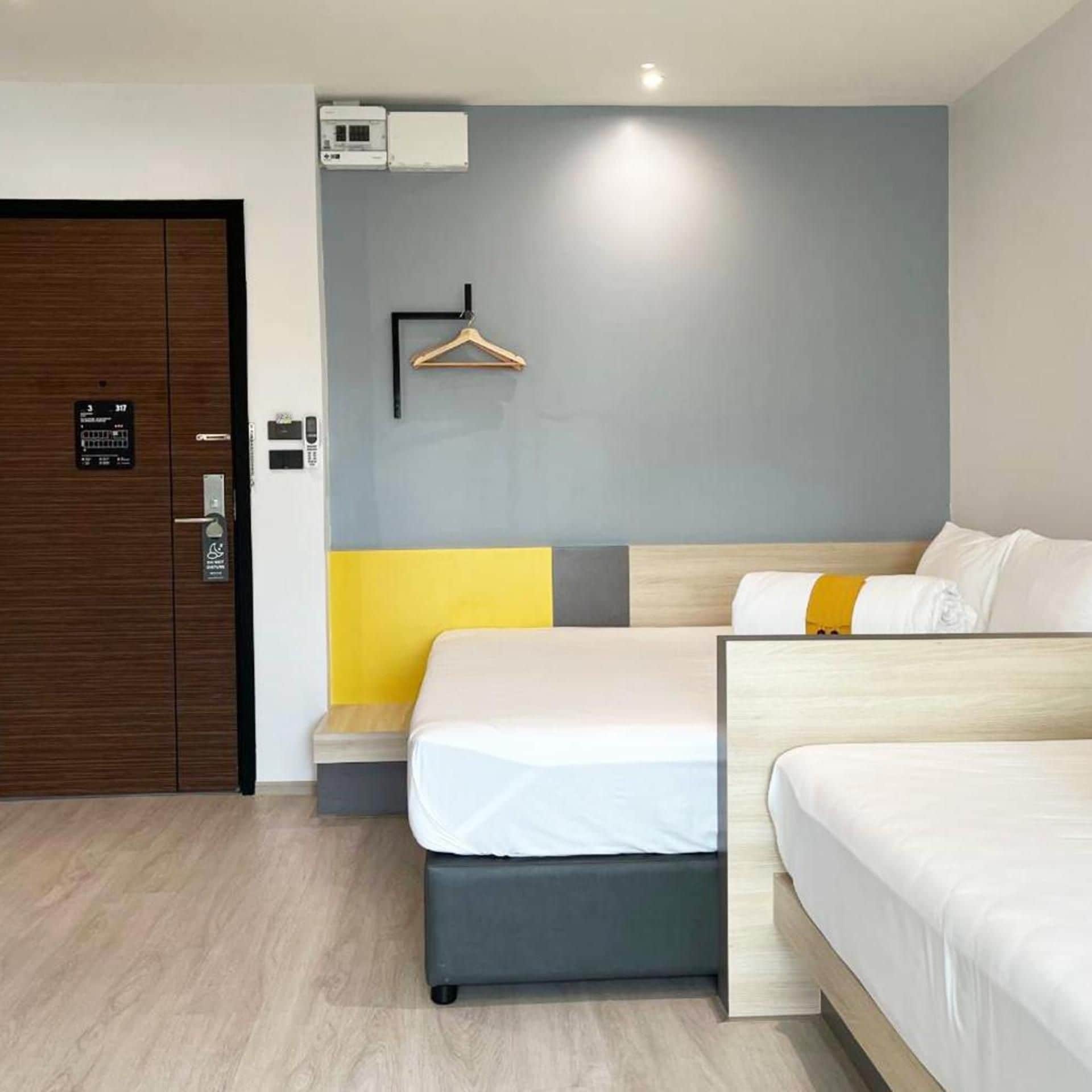 Una camera d'albergo con un letto, un comodino e un armadio.