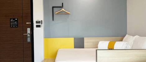 Una habitación de hotel con cama, mesita de noche y armario.
