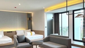 Habitación de hotel moderna con cama, dos sofás, una mesita pequeña y un ventanal con vistas.