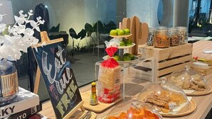 Una mesa de buffet con diversos alimentos y un cartel que dice 'Cafe Cure Fresh'.