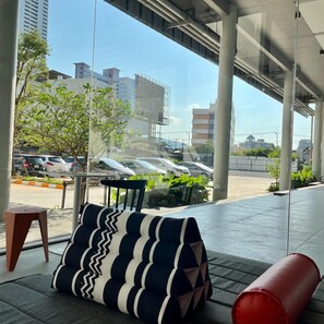 A modern outdoor seating area with a view of a parking lot and buildings. - Hatyai Midtown Hotel (Hat Yai)