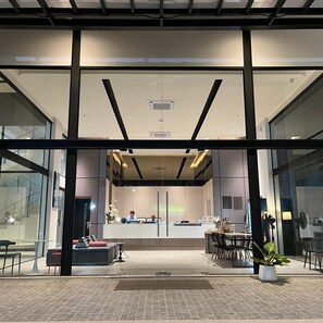 A modern hotel lobby with a reception desk, seating area, and large windows. - Hatyai Midtown Hotel (Hat Yai)