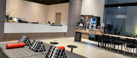 Un moderno vestíbulo de hotel con recepción, zona de estar y un bar.