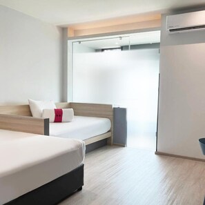 A modern hotel room with a bed, a bedside table, and a wardrobe.