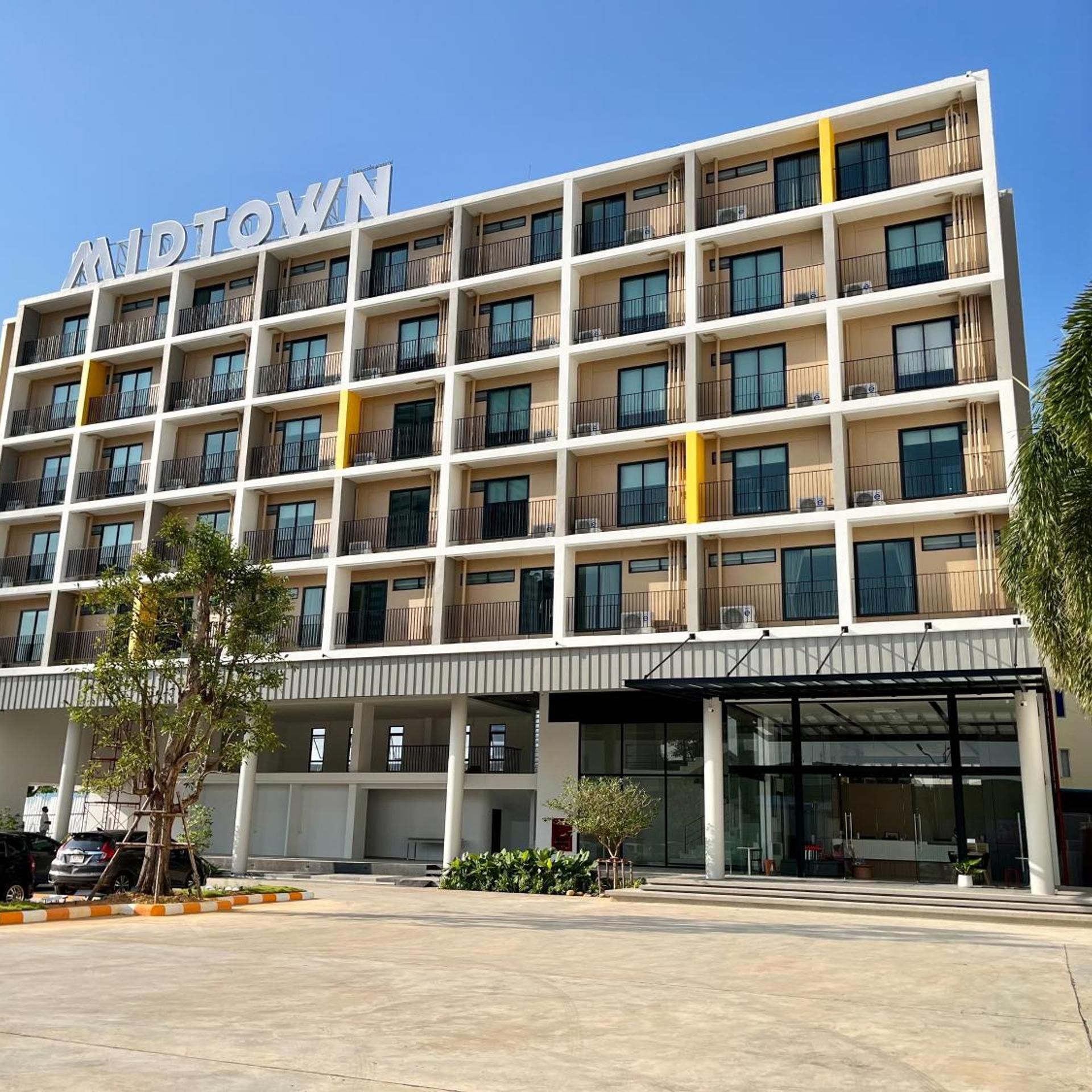 A multi-story hotel with a modern design, featuring balconies on each floor and a clear entrance.