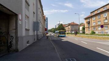 A street with buildings, a bus, and a sidewalk.