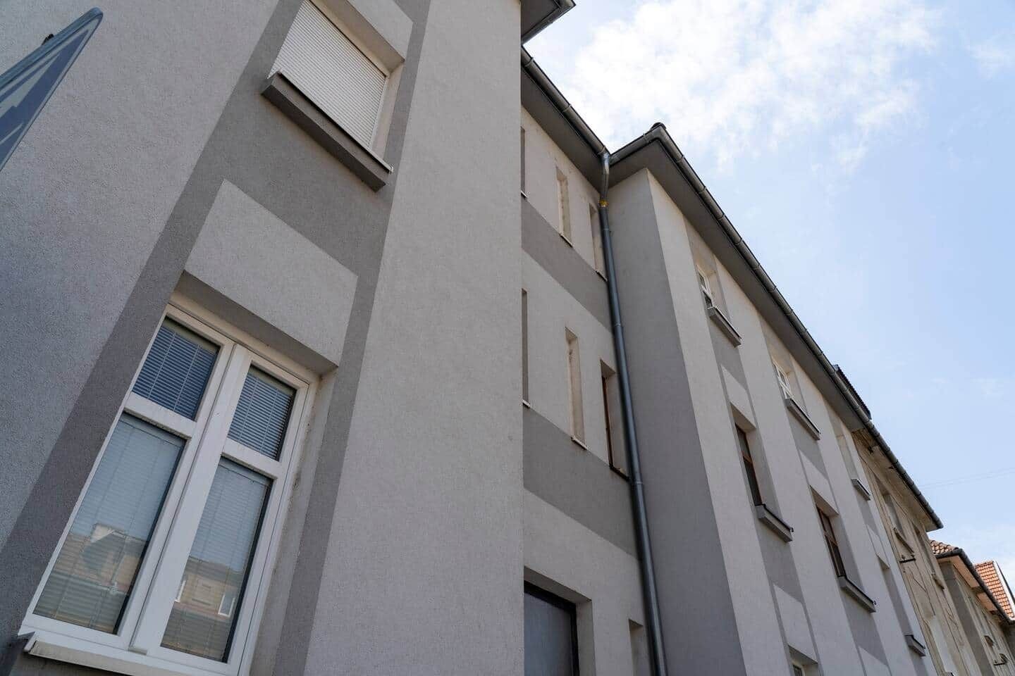 A multi-story building with a modern architectural style, featuring rectangular windows and a flat roof.