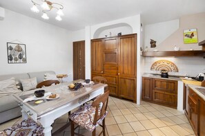 Una cocina moderna con armarios de madera, una mesa de comedor con sillas y piso de baldosas.