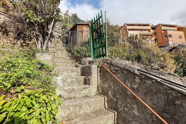 A staircase leading to a gated entrance with a building in the background.