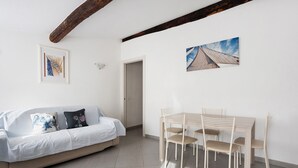 A room with a sofa, a dining table with chairs, a framed picture on the wall, and a door. - Apartment 'Donadelmar2' with Sea View and Wi-Fi (Riomaggiore)