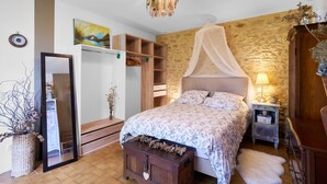 Un dormitorio con cama, espejo, armario, mesita de noche y lámpara.