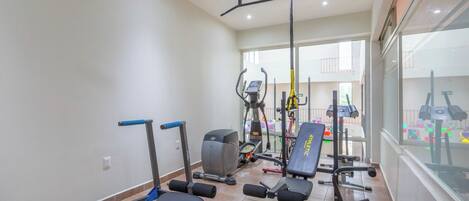 A gym with various exercise equipment, including treadmills, stationary bikes, and weight machines.