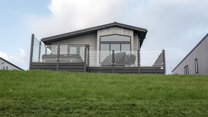Un bâtiment moderne doté d’une grande façade en verre, d’un toit en pente et d’une extension de toit plat.