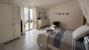 Quarto com cama, cômoda, cadeira e guarda-roupa.