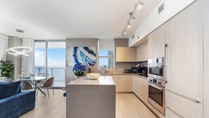 A modern kitchen with a central island, stainless steel appliances, and a view of the city.