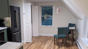 A compact kitchen with a built-in stove, a black refrigerator, and a window with a view of a house. - Perfectly Located 1 Bedroom, newly remodeled  (Augusta)