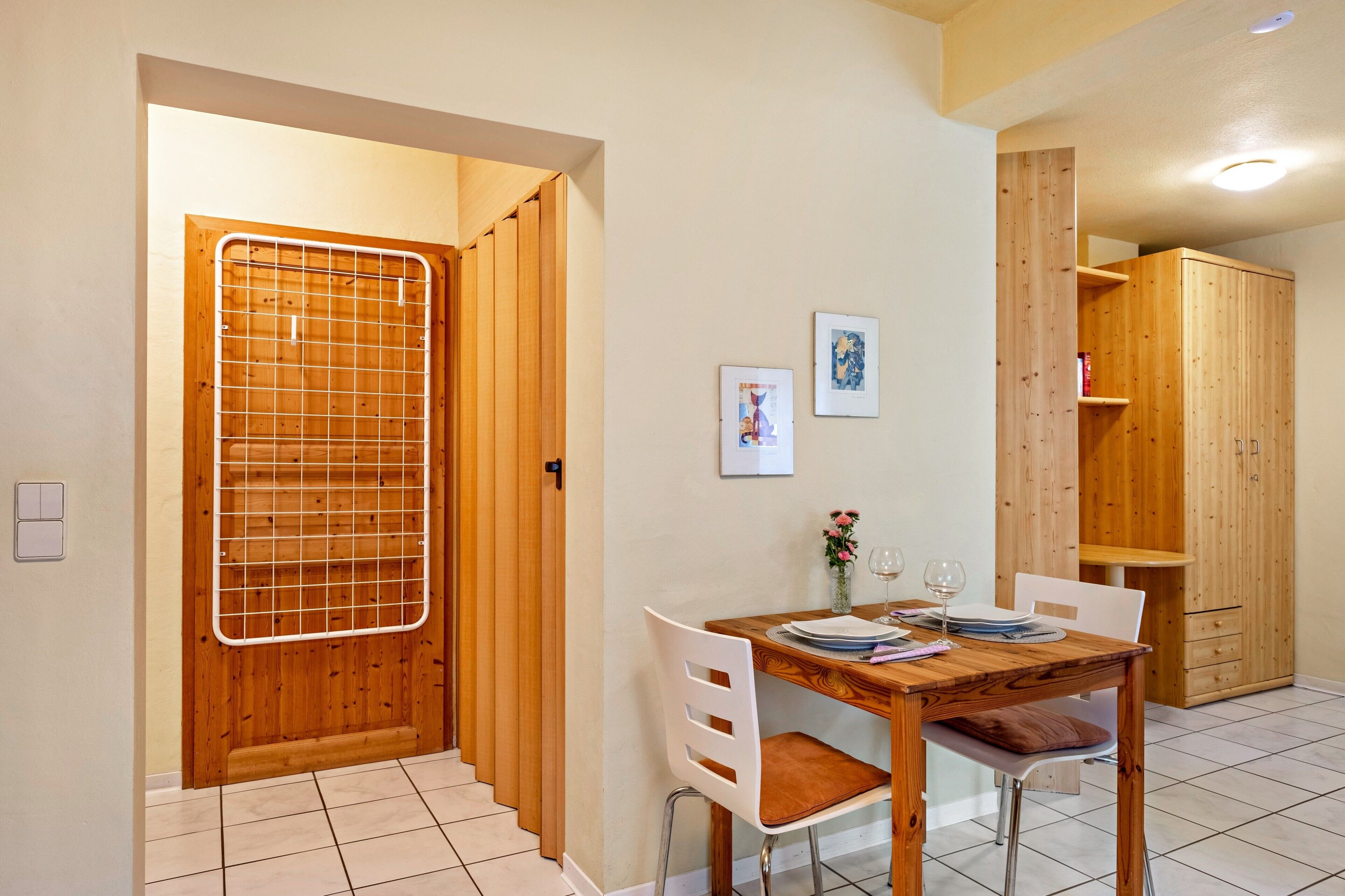Un comedor con una mesa de madera, sillas y un mueble bajo.