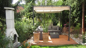 A patio with a stone fireplace, outdoor seating, and a pergola. - Studio '38 sqm' with Terrace, Shared Garden and Wi-Fi (Unterkirnach)