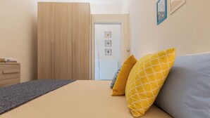 Une chambre à coucher avec un lit, des oreillers, une commode et une armoire.