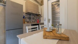 Une cuisine moderne avec un réfrigérateur en acier inoxydable, des armoires en bois et un crédence décorée.