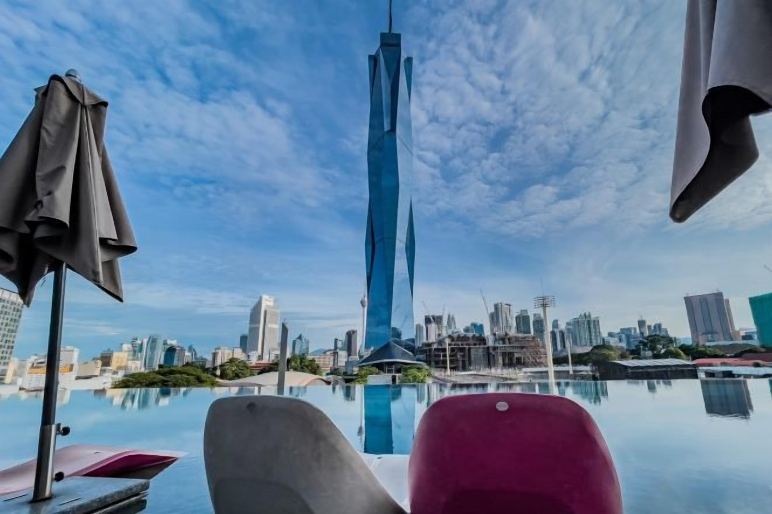 A poolside view with a city skyline in the background.
