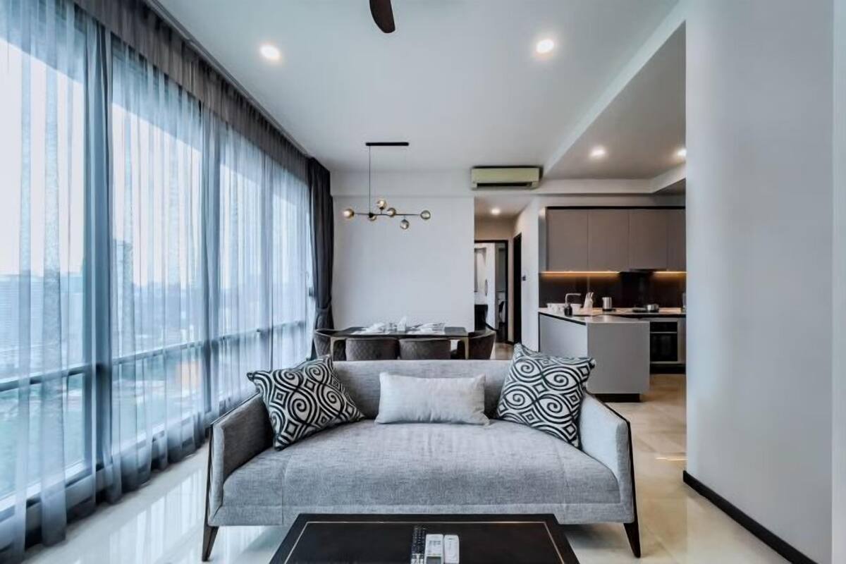 Una sala de estar moderna con un sofá, una mesa de centro y una zona de comedor al fondo.