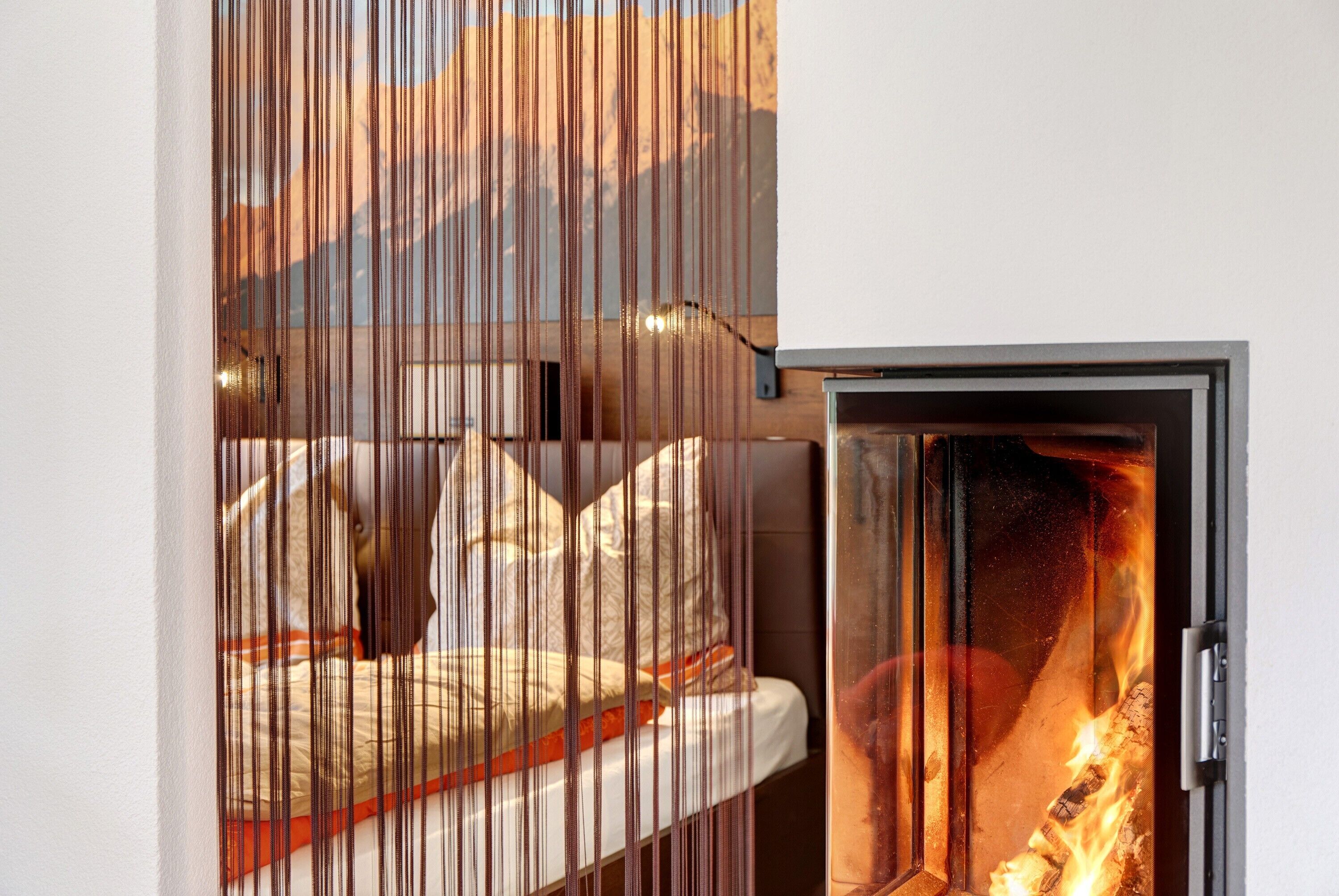 Ein Zimmer mit einem Bett, einem Kamin und Bergblick.