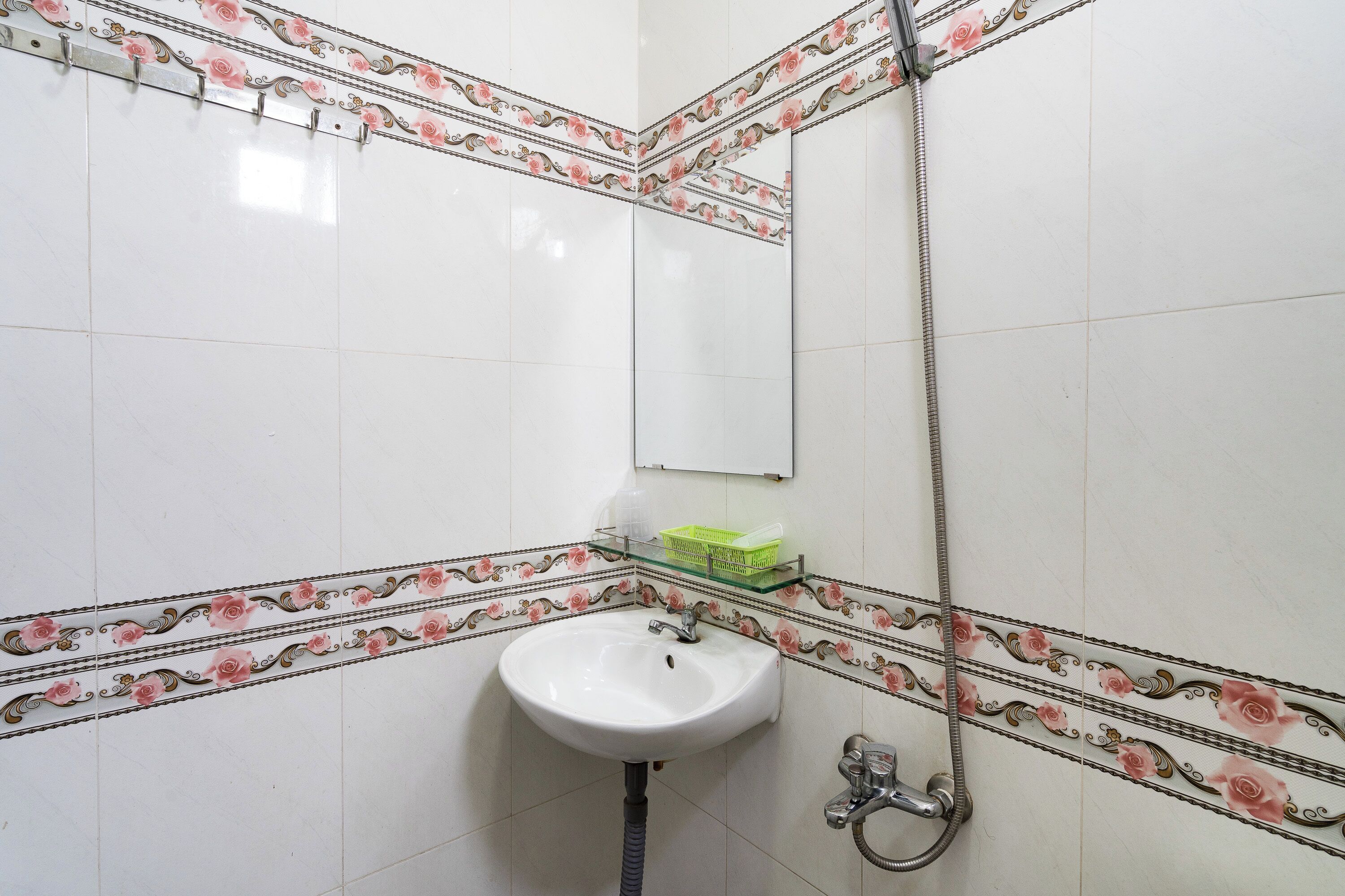 A bathroom with a white sink, a mirror, and a shower.