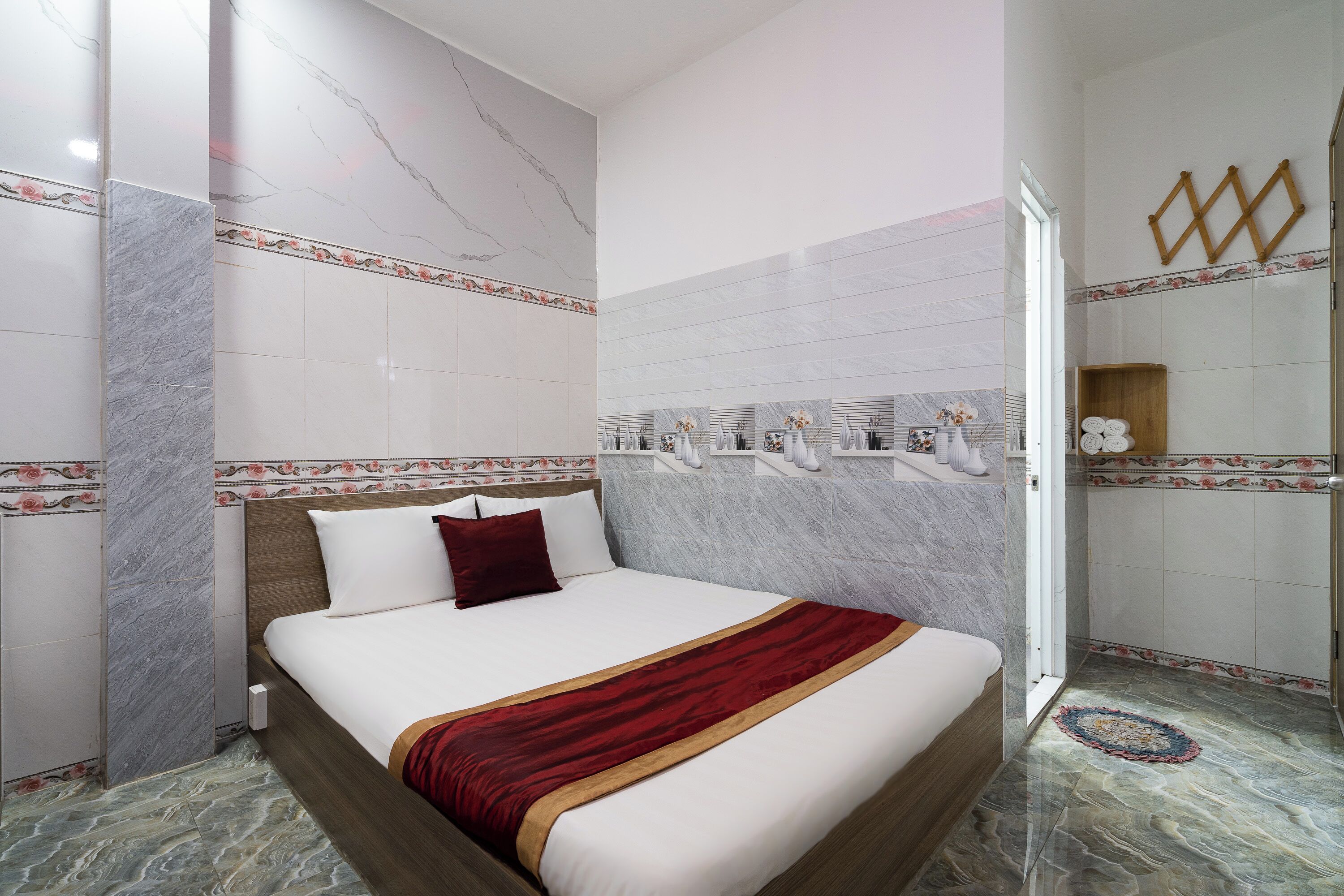 A hotel room with a large bed, marble walls, and a shower area.
