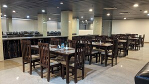 A restaurant with multiple tables and chairs, a counter with kitchen equipment, and a tiled floor. - Cityhouse - Abora (Kasaya)
