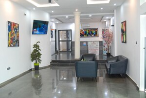 Un lobby moderno con mostrador de recepción, zona de estar y obras de arte en las paredes.
