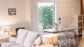 Una sala de estar acogedora con un sofá, una mesa de centro y un comedor con sillas y una mesa.