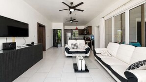 A modern living room with a flat-screen TV, a sofa, a coffee table, and a ceiling fan. - Sunlit Pool Hideaway ● 2 En-Suite Kings (Sosúa)