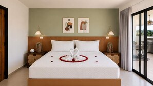 Una cama grande con una colcha blanca, dos lámparas de pared y un cabecero de madera.