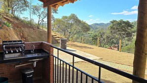 A balcony with a barbecue grill and sink, overlooking a hilly landscape. - Villa da Serra Studio Ibitipoca (Lima Duarte)