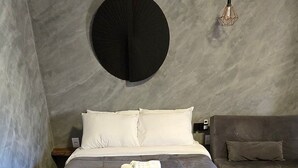 A modern bedroom with a large bed, a round mirror, and a hanging light fixture. - Villa da Serra Studio Ibitipoca (Lima Duarte)