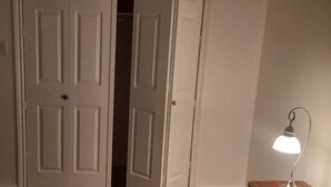 A room with white doors, a desk with a lamp, and a wooden chair. - Walk out to Salmon Creek (Bowmanville)