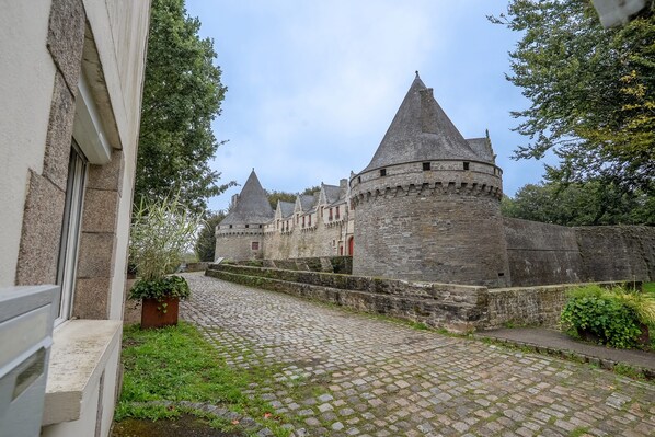 A historic stone building with multiple towers and a cobblestone pathway.
