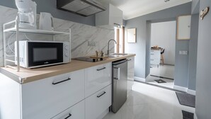 A modern kitchen with a microwave, coffee maker, and stainless steel dishwasher.
