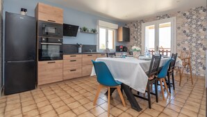 A modern kitchen with a dining area. - Le gite de la petite famille - proche lacs (Cornod)