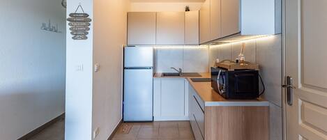 Fridge, microwave, coffee/tea maker, cookware/dishes/utensils