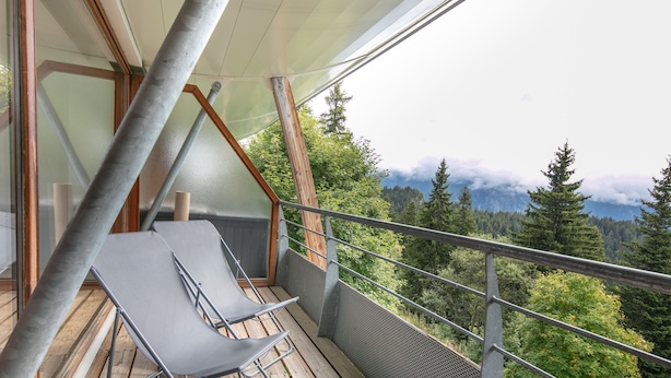 Ein Balkon mit Blick auf Wald und Berge.