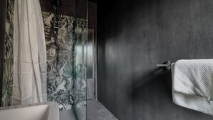 A modern bathroom with a glass shower enclosure, a white bathtub, and a towel rack. - Minimal Chic Studio near Milan Centrale (Milan)