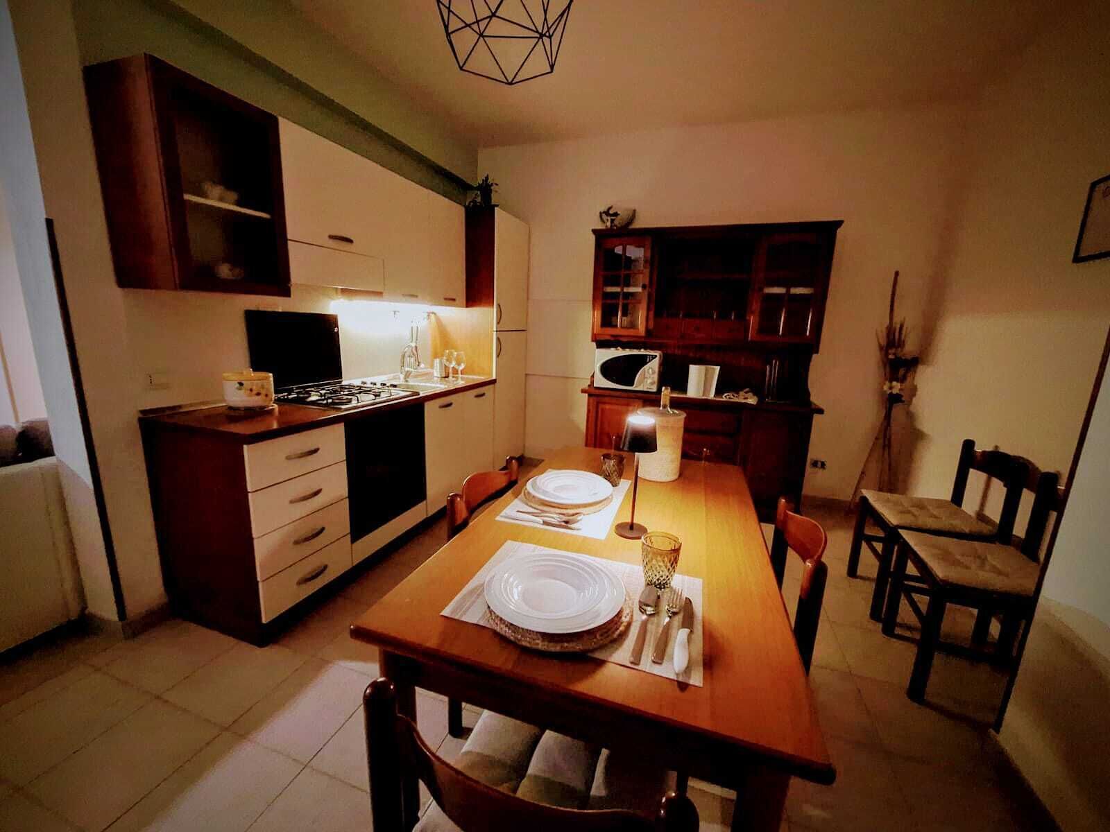 Una cucina compatta con un tavolo da pranzo per due persone, un fornello e pensili.