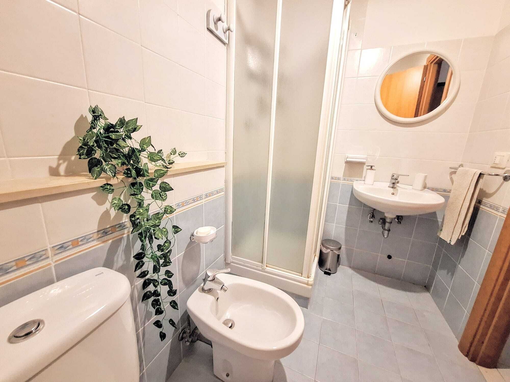 Un bagno con toilette, bidet, lavandino e cabina doccia.
