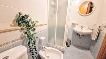 Un bagno con toilette, bidet, lavandino e cabina doccia.