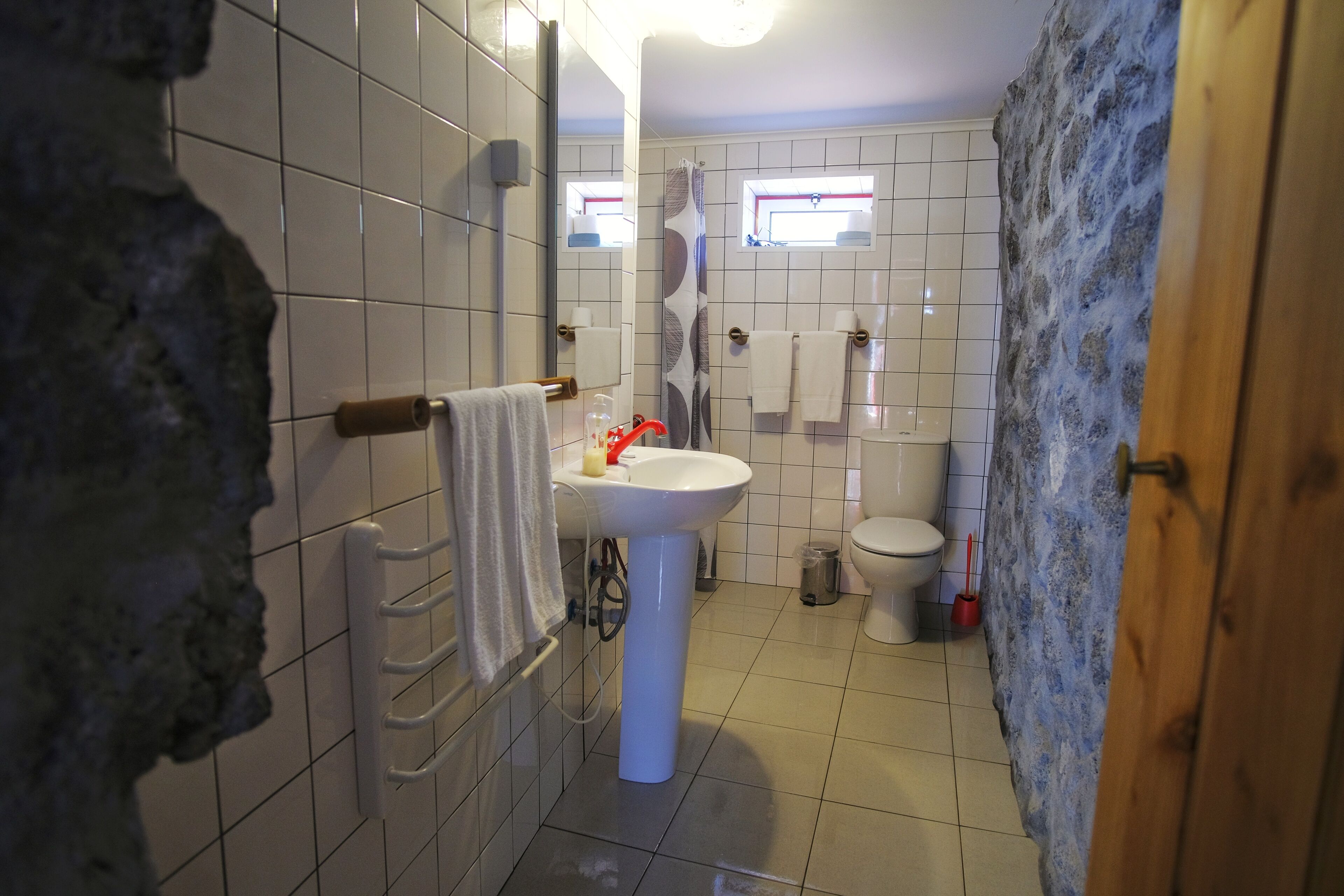 Een badkamer met een witte wastafel, toilet en douchehoek.